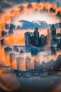 Digital composite image of buildings against sky during sunset