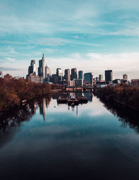 River amidst buildings in city against sky