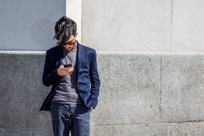 Full length of man using mobile phone in city