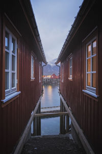 Buildings by lake against sky