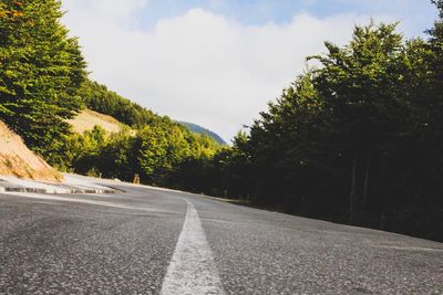 Road amidst trees against sky