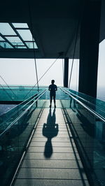 Full length of man standing on walkway in modern building