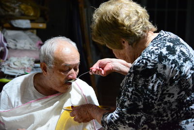 Woman feeding man at home