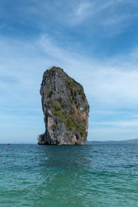 Rock formation in sea against sky