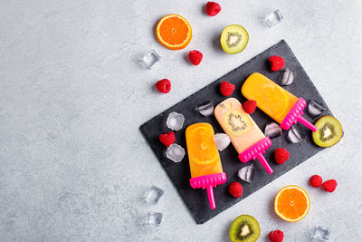 High angle view of chopped fruits on table against white background
