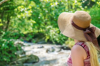 Rear view of woman wearing hat on rock