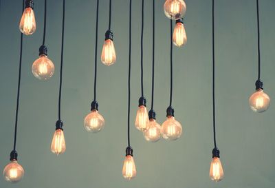 Low angle view of light bulb hanging from ceiling
