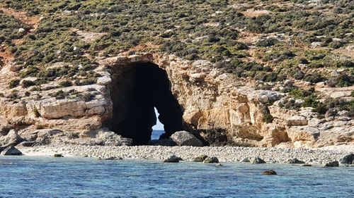 Man standing on rock by sea