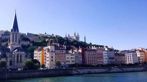 River by city against clear blue sky