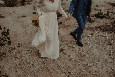 Low section of couple walking on land