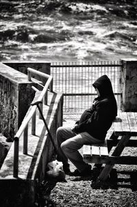 Side view of man sitting on bench