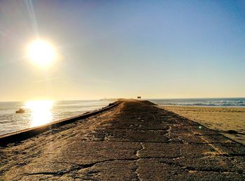 Scenic view of beach against clear sky during sunset