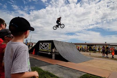 Rear view of people in mid-air against sky