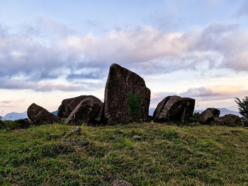 Rock formations on field against sky