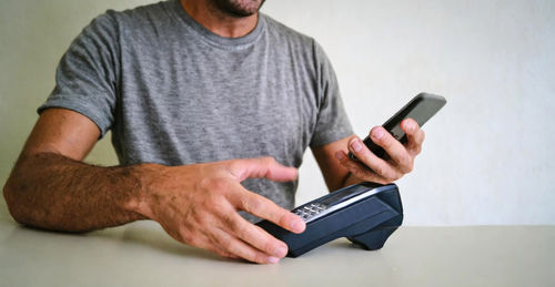 Midsection of man using mobile phone