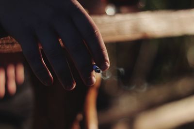 Cropped hand of person holding cigarette