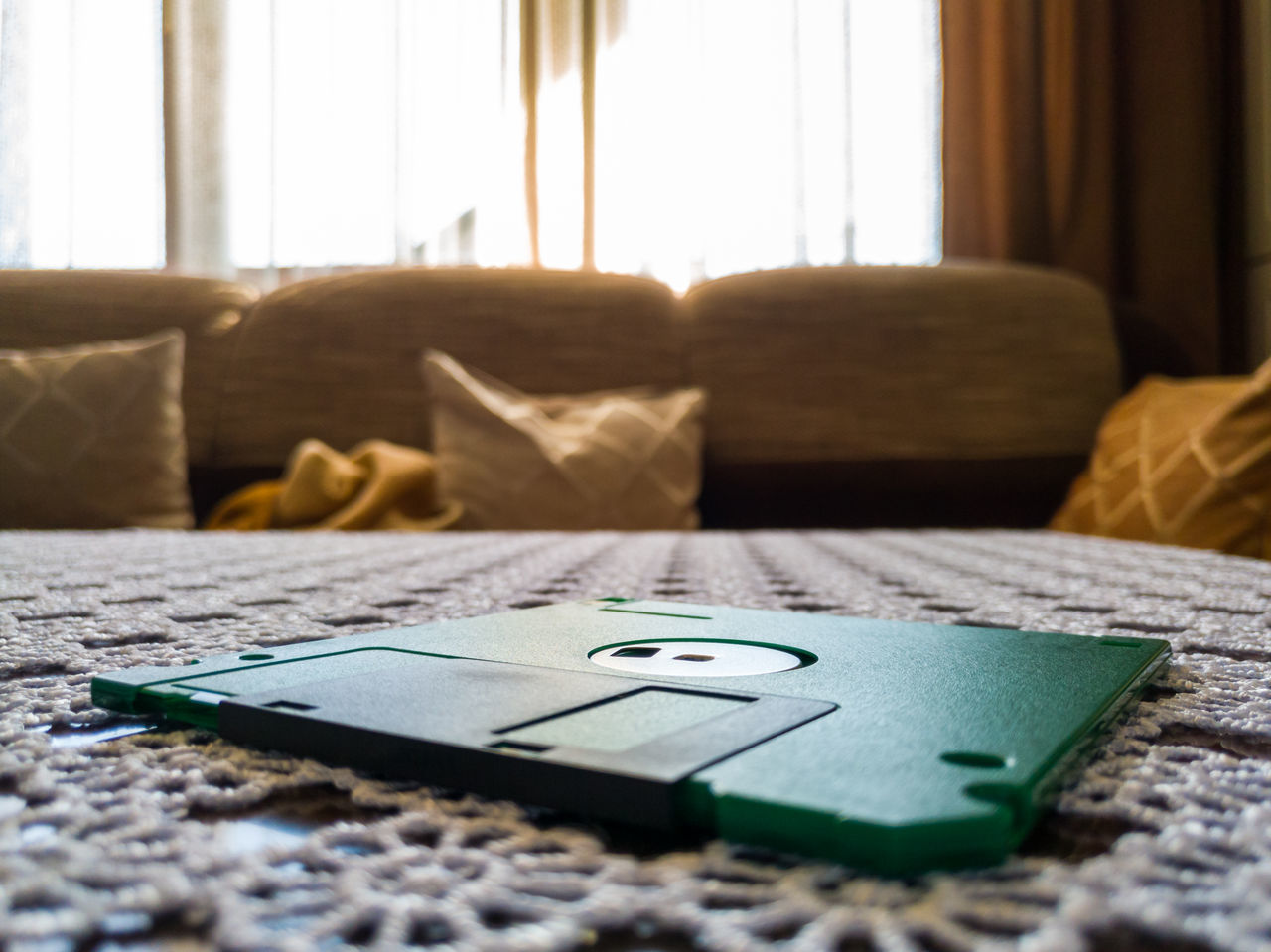 CLOSE-UP OF MOBILE PHONE ON SOFA