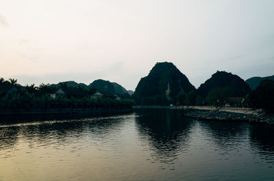 Scenic view of lake by mountains against sky