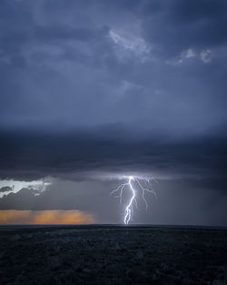 View of lightning over sea against storm clouds