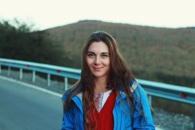 Portrait of young woman standing on road