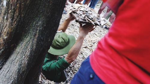 Low section of woman on tree trunk