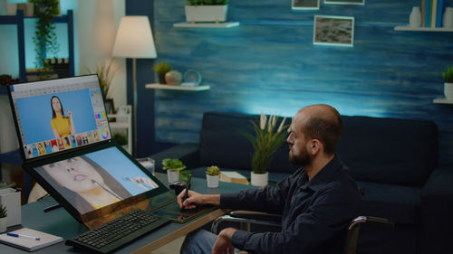 Side view of man using laptop at home