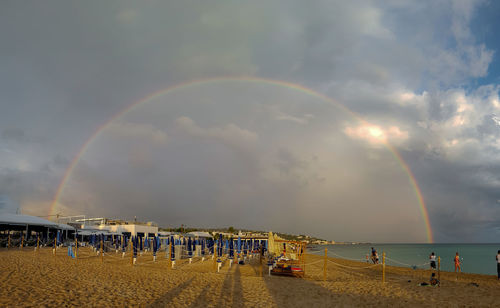 Scenic view of rainbow over sea against sky