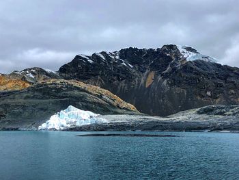 Scenic view of sea and snowcapped mountain against sky