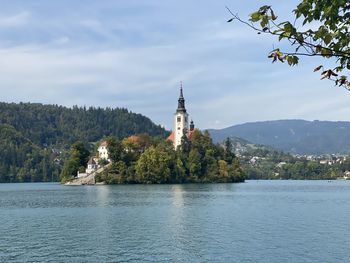 Scenic view of building by trees against sky