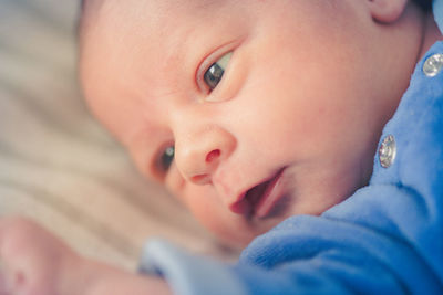 Close-up of newborn baby lying on bed