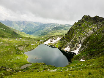 Scenic view of lake amidst mountains against sky