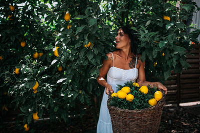 Woman standing by fruits in basket