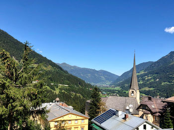 Houses and buildings against clear blue sky