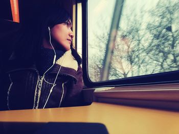 Woman looking through window in train