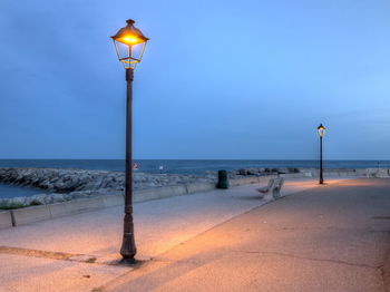 Street light on beach against sky