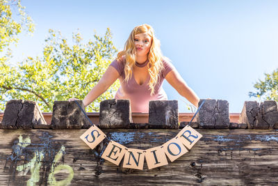 Portrait of teenage girl making face with message standing on terrace