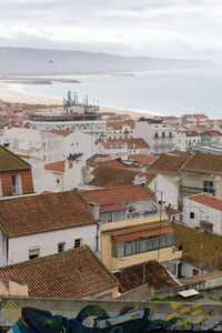 High angle view of townscape by sea against sky