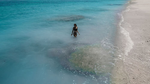 High angle view of woman standing in water at beach