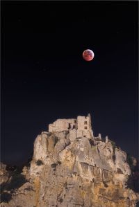 Low angle view of rock against sky at night