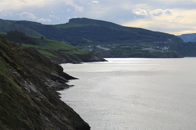 Scenic view of sea and mountains against sky