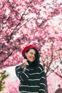 Young woman standing against trees