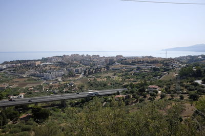 Scenic view of landscape and sea against clear sky