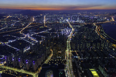 High angle view of city lit up at night