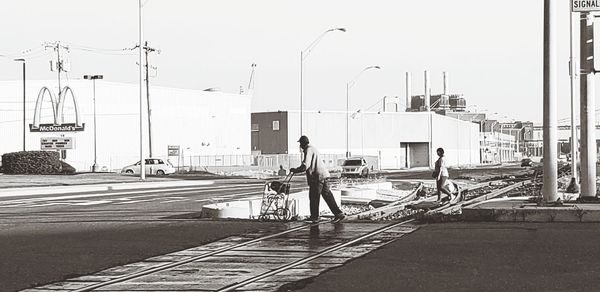 Man walking on railroad tracks against clear sky