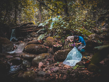 Woman standing on rock in forest