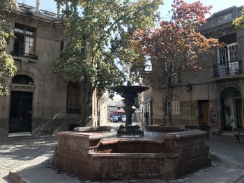 View of fountain in city against building
