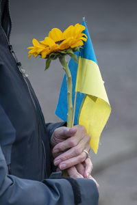 Midsection of man holding yellow flower