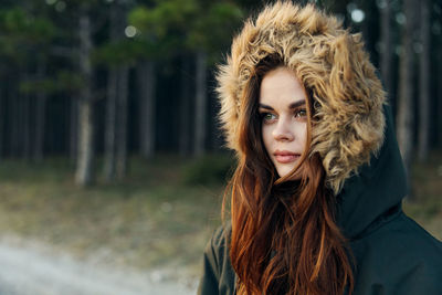 Young woman wearing fur hat while standing outdoors