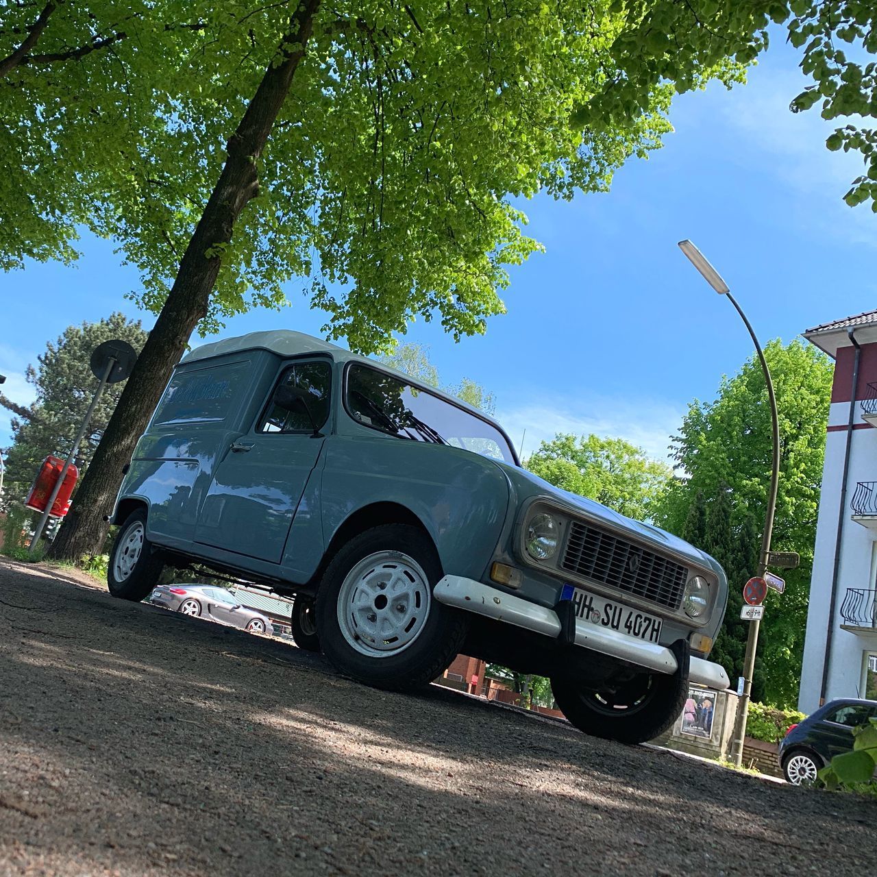 VINTAGE CAR ON ROAD AGAINST TREES