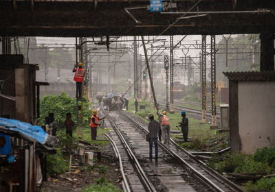 Workers working on railroad tracks during rainfall